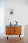 Pale, wooden retro cabinet against white wall