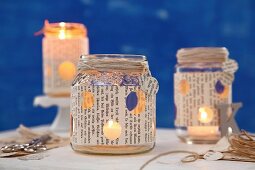 Candle lanterns hand made from old jam jars covered with book pages