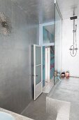 Futuristisches Duschpodest mit Glasabtrennung in silbern lackiertem Badezimmer, strahlenförmige Wanduhr