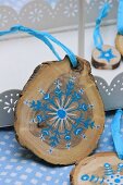 Christmas decorations made from small slices of tree trunk painted with blue and white stars