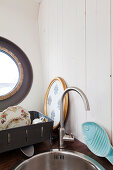 Sink unit with round sink and dish rack next to porthole window