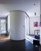 View from kitchen area to living area and hallway in modern, architect-designed house with round, feng shui partition wall