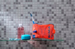 Water wing upcycled into toilet bag in front of grey mosaic-tiled wall