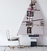 Stylised, triangular, cardboard Christmas tree decorated with ribbons and black and white family photos