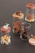 Animal-shaped biscuits in storage jars with matching animal figurines