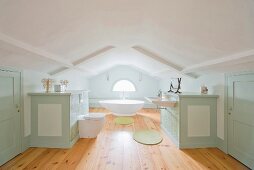 Custom fittings and bathroom suite in white and pastel green in large attic bathroom with rustic ambiance
