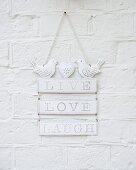Romantic, white, shabby-chic metal sign decorated with bird figurines hung on wall
