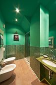 Modernes Bad mit schimmernden Mosaikfliesen in verschiedenen Grüntönen, dazu grüne Wand- und Deckenfarbe