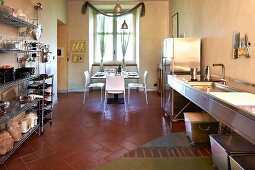 Purist, stainless steel kitchen and dining area in restored, Italian manor house