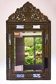 Reflections in antique mirror with ornate metal frame on wall (Villa Cimbrone)