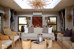 Elegante Sofagarnitur und Sessel um Baumstamm-Möbel als Couchtisch, in Loungebereich