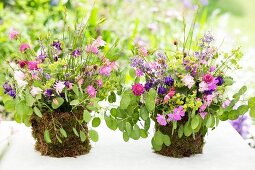 Posies of aquilegia and lady's mantle in DIY vases wrapped in moss