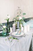 Feenhaft gedeckter Hochzeitstisch mit Vogelkäfig und vielen Kerzen