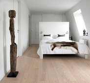 Sculpture in bedroom with bed against partition