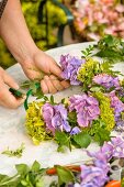 Tying a wreath of flowers and herbs