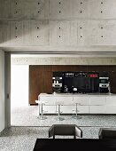 Open-plan kitchen with modern island counter and concrete walls