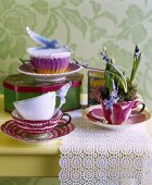 Vintage-style china cups and tin on lace doily on table