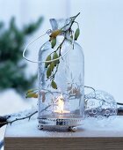 Glass candle lantern decorated with sprig of rose hips