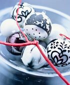 Hand-decorated Christmas baubles on glass plate