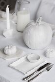 Gedeckter Tisch mit Halloweendeko in Weiß