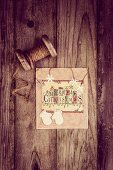 Christmas card and vintage reel of string on rustic wooden surface