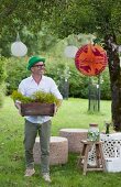 Mann hält Holzkiste im Garten mit Partystimmung