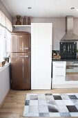 Kitchen in natural shades with bronze retro fridge and cowhide rug
