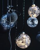 Black and glass Christmas baubles hanging from ribbons