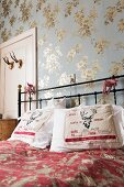 Scatter cushions printed with festive reindeer motifs on metal bed