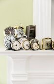 Collection of various old alarm clocks on mantelpiece