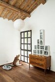 Antique chest of drawers, framed modern sculptures and large chimeric sculpture in renovated attic room