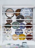 Colourful decorative wall plates in display case