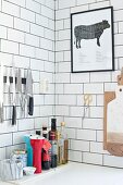 Kitchen utensils on shelf below collection of knives on white subway tiles
