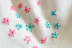 Flowers embroidered in lazy daisy stitch on a woollen blanket