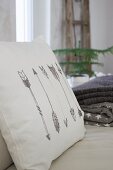 Cushion with arrow motifs printed on white cover