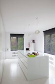 Minimalistischer Ankleideraum mit zentralem weißem Schubladenschrank, weissen Designerleuchten und Fenstern mit schwarzen Jalousien
