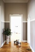 Grey-painted walls, white door frame and herringbone parquet floor in hallway