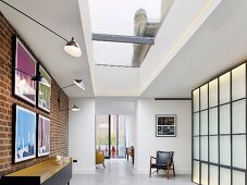 Skylight, brick wall and backlit wall elements in apartment foyer