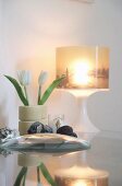Cityscape picture on illuminated lampshade and plastic tulips arranged in old skateboard wheels