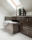 Upholstered trunk seat in front of custom sideboard with vanity mirror under skylight