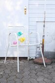 White lattice garden chair decorated with pastel balloons