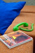 Neon-green telephone handset and book lying on sofa