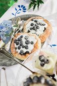 Blueberry tartlets and silver cutlery on table set for afternoon coffee