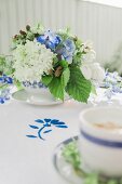 Table set with flowers in blue and white for afternoon coffee