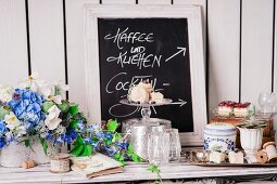 Summery flower arrangements and hand-writing sign on buffet table