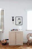 Fabric balls arranged on top of half-height cabinet below framed picture