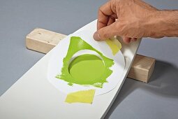 Revamping a chair backrest with green paint and circular stencil