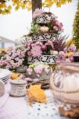 Autumnal arrangement of flowers on cake stand on set table