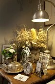 Vintage arrangement of family photos in antique silver frames and retro table lamp on side table