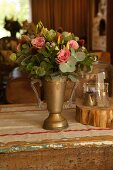 Blumenstrauss in pokalförmiger Vase aus Messing